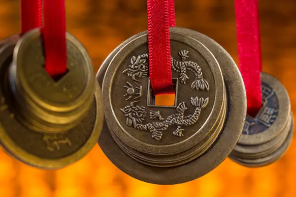 Chinese feng shui coins tied with red ribbons, symbolizing the value and prosperity gained from a feng shui consultation Chinese feng shui coins tied with red ribbons, symbolizing the value and prosperity gained from a feng shui consultation