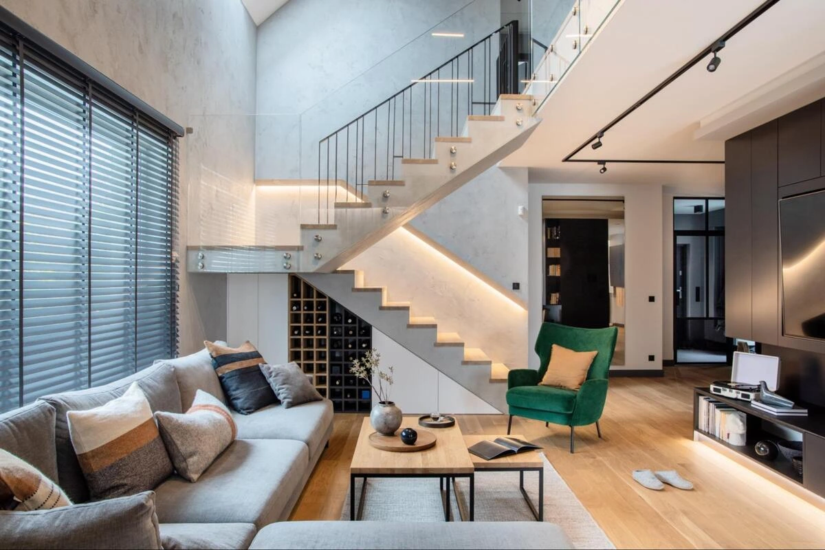 Renovated Open-Plan Living Room Open-plan living room with a staircase, grey sofa and green armchair in a renovated Singapore home