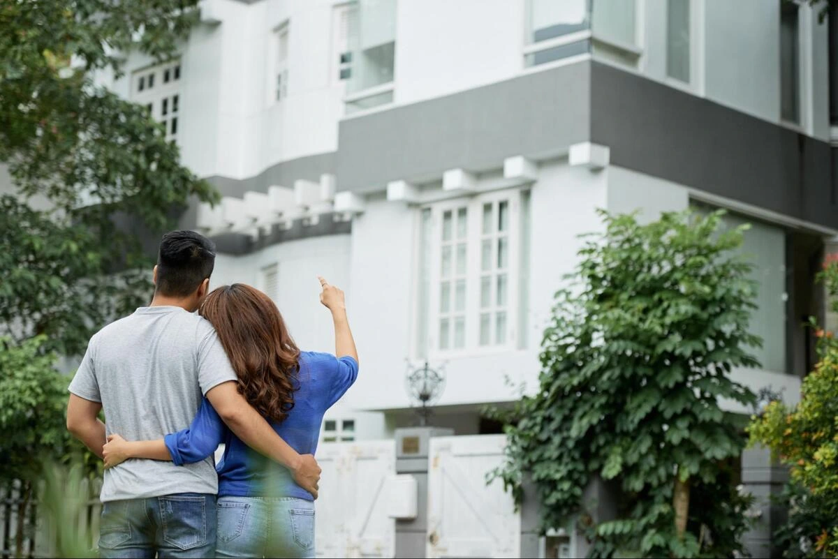 Assessing a Home's Facing Direction Couple standing outside a house looking up and pointing at the property